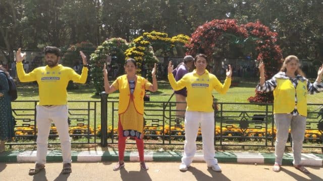 Praticanti della Falun Dafa meditano accanto alla loro esposizione e al loro stand alla 213a mostra annuale di fiori a Bangalore, in India, durante le celebrazioni della Festa della Repubblica indiana, il 26 gennaio 2023.