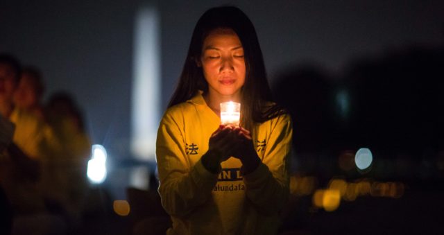 Una donna si unisce ai praticanti del Falun Gong durante una veglia a lume di candela al Lincoln Memorial di Washington DC, il 20 luglio 2017. La veglia vuole onorare coloro che sono morti durante la persecuzione in Cina, iniziata dal regime cinese il 20 luglio 1999. (Benjamin Chasteen)