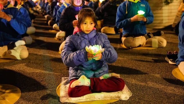 I praticanti del Falun Gong durante una veglia a lume di candela davanti al consolato cinese a New York City il 21 aprile 2024. (Larry Dye/The Epoch Times)